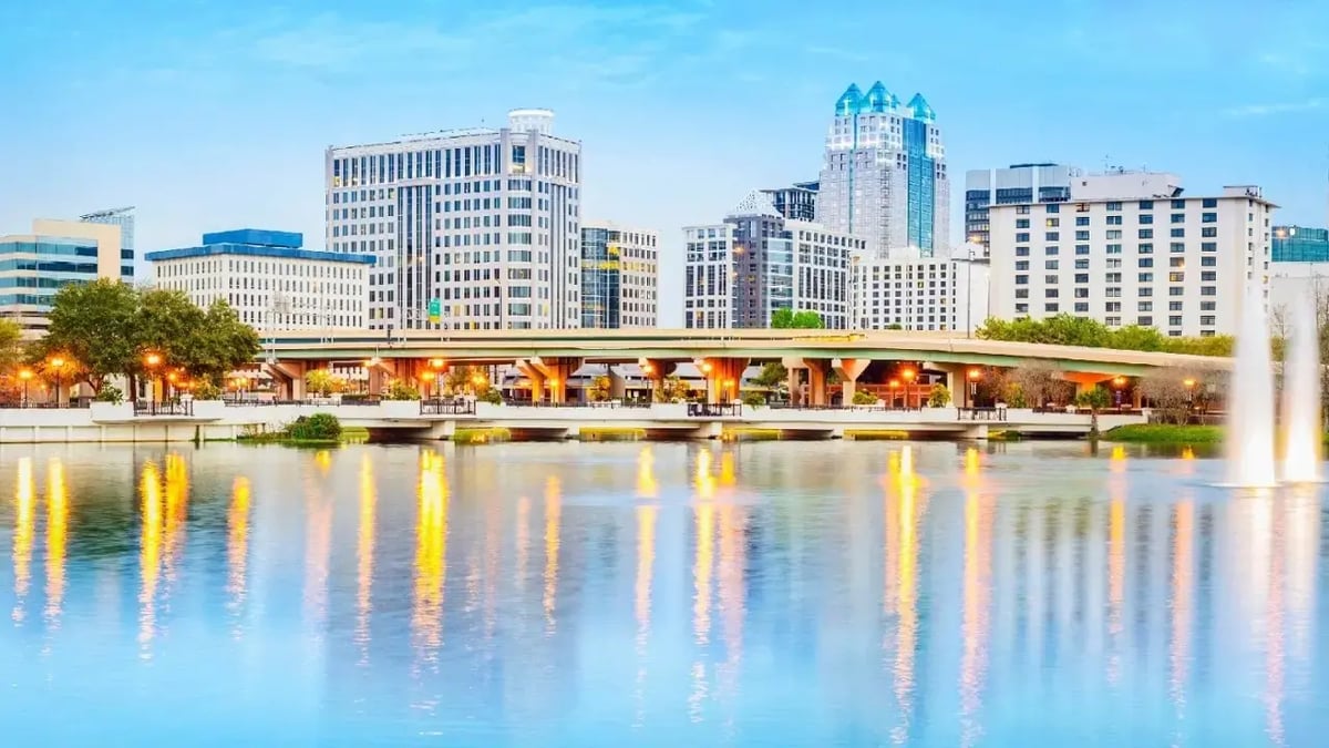 Downtown Orlando skyline with water reflection at sunset